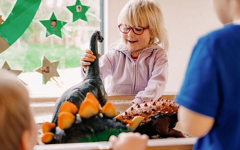 Kinder spielen mit Dinosauriern