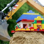 Kita Neubau: Baggerarm mit Duplo auf Sandhaufen